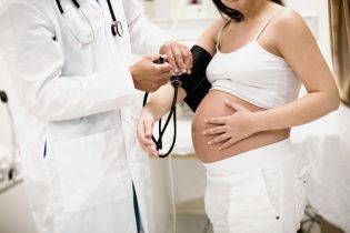lekarz bada kobietę w ciąży