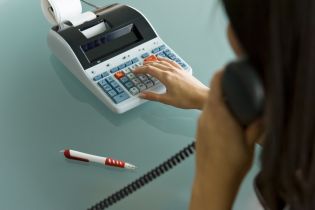 kalkulator księgowy - kobieta liczy coć i rozmawia przez telefon