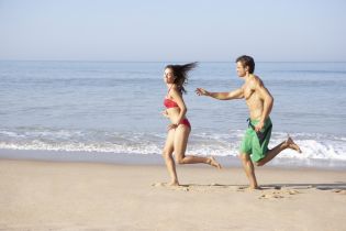 plaża - dwie osobu biegna po plaży