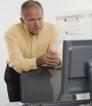 mężczyzna patrzy na monitor i zastanawia się