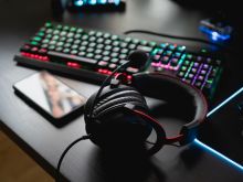 play-from-home-concept-top-view-gaming-gear-mouse-keyboard-joystick-headset-mobile-joystick-ear-headphone-mouse-pad-black-table-background-with-copy-space
